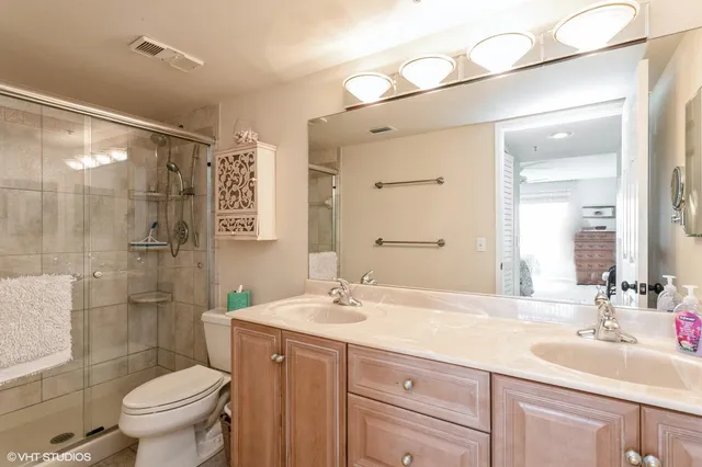 a bathroom with a double vanity sink toilet and shower