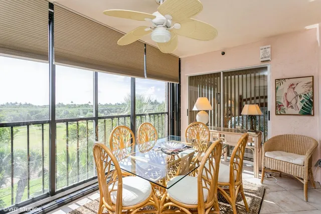 a dining room with furniture water view and a floor to ceiling window