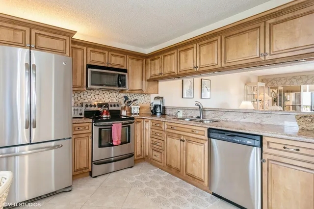 a kitchen with granite countertop cabinets stainless steel appliances and a sink