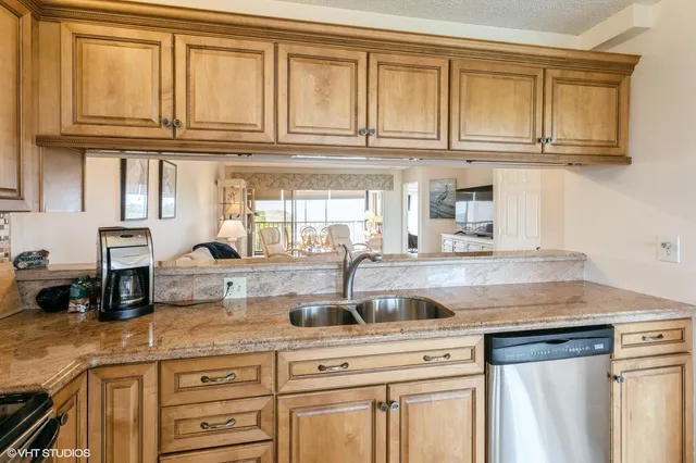 a kitchen with granite countertop a sink and cabinets