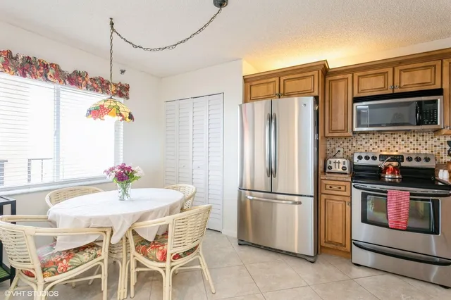 a kitchen with stainless steel appliances granite countertop a refrigerator and a stove top oven