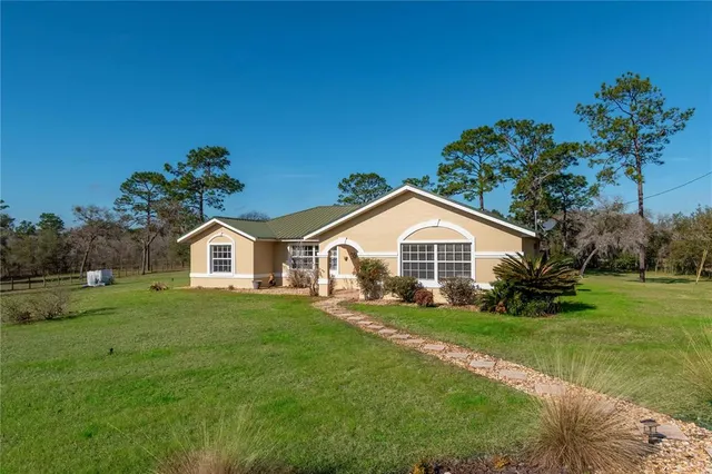 a front view of a house with a garden and yard