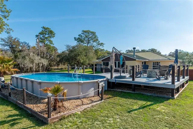 an aerial view of a house with swimming pool and lake view