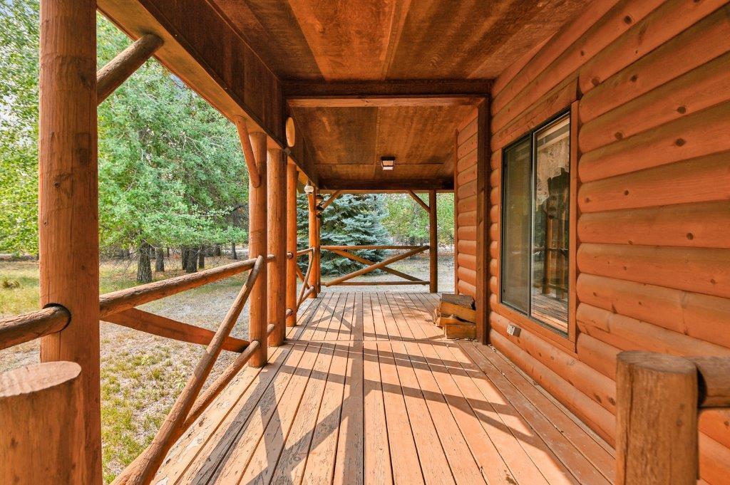 Log accents and covered deck make for an inviting entrance to this cozy home.