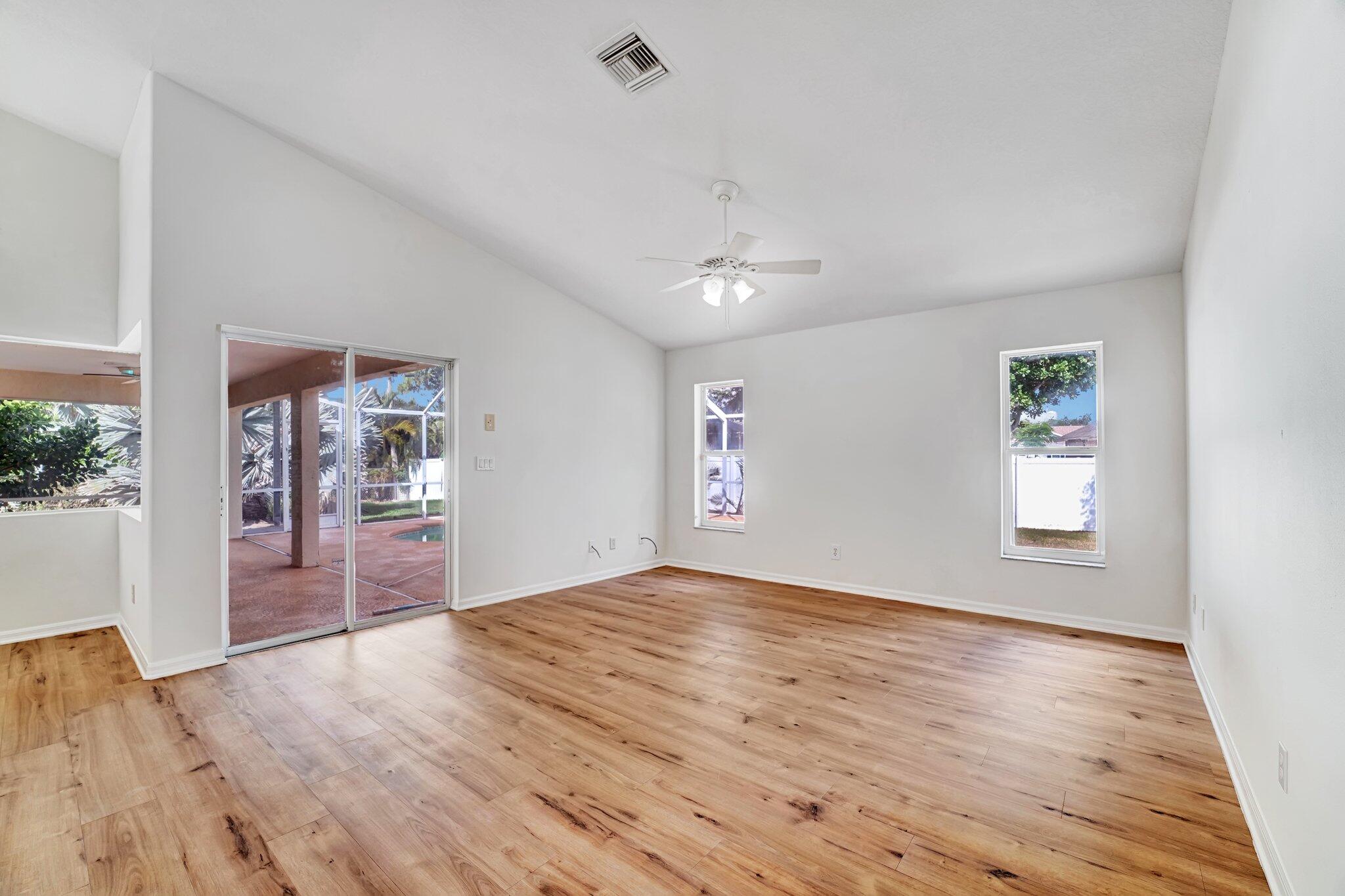 513 Southeast Cliff Road Port St. Lucie, FL 34984 - Photo 11 of 39 wooden floor in an empty room with a window