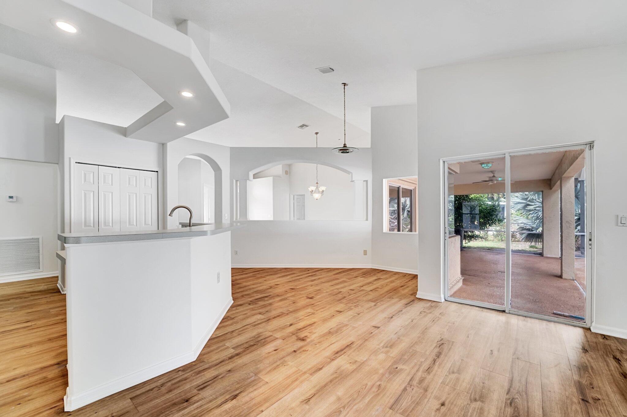 513 Southeast Cliff Road Port St. Lucie, FL 34984 - Photo 12 of 39 a view of empty room with wooden floor and outdoor view