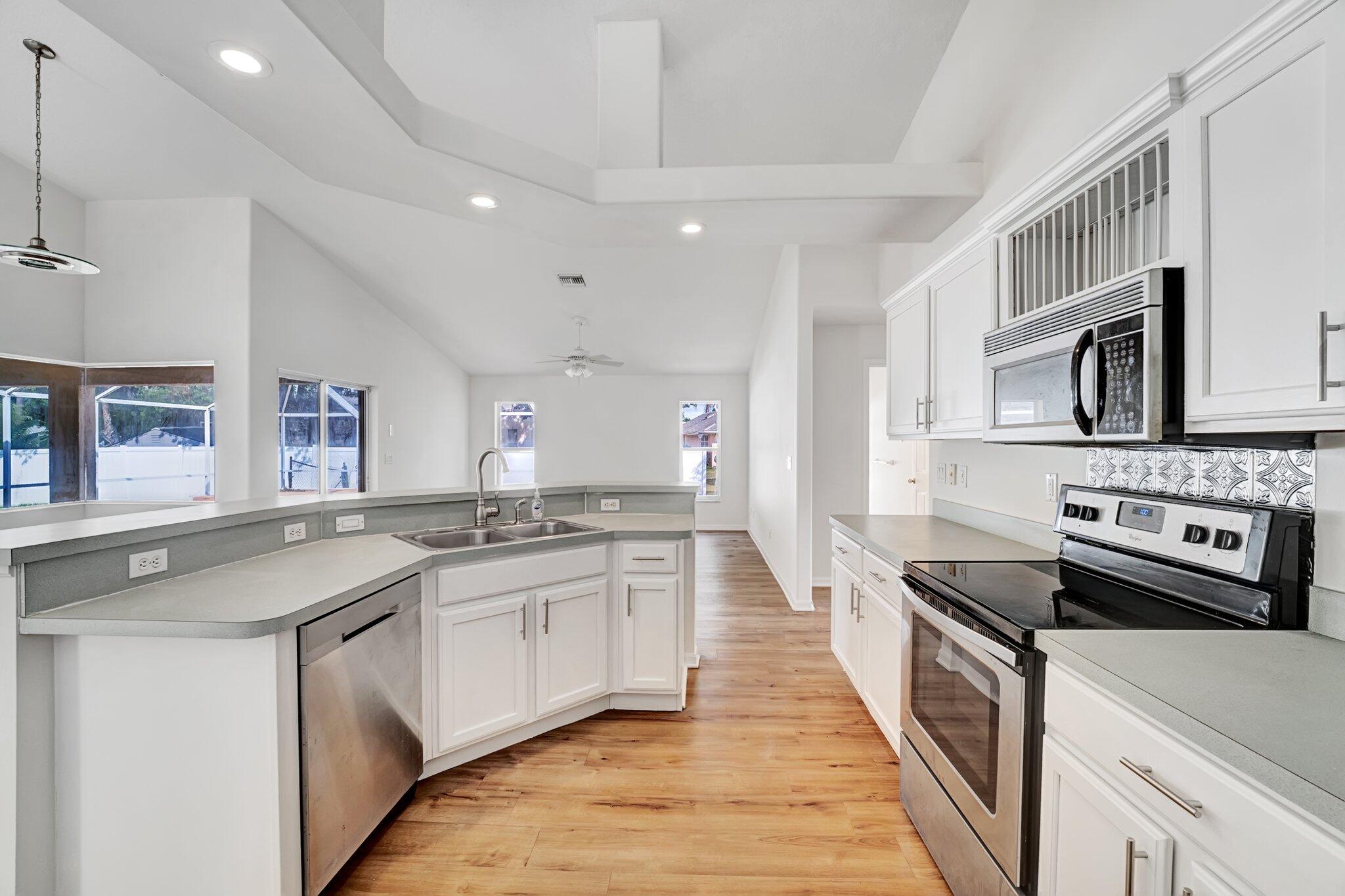 513 Southeast Cliff Road Port St. Lucie, FL 34984 - Photo 20 of 39 a kitchen with stainless steel appliances granite countertop a sink stove and cabinets