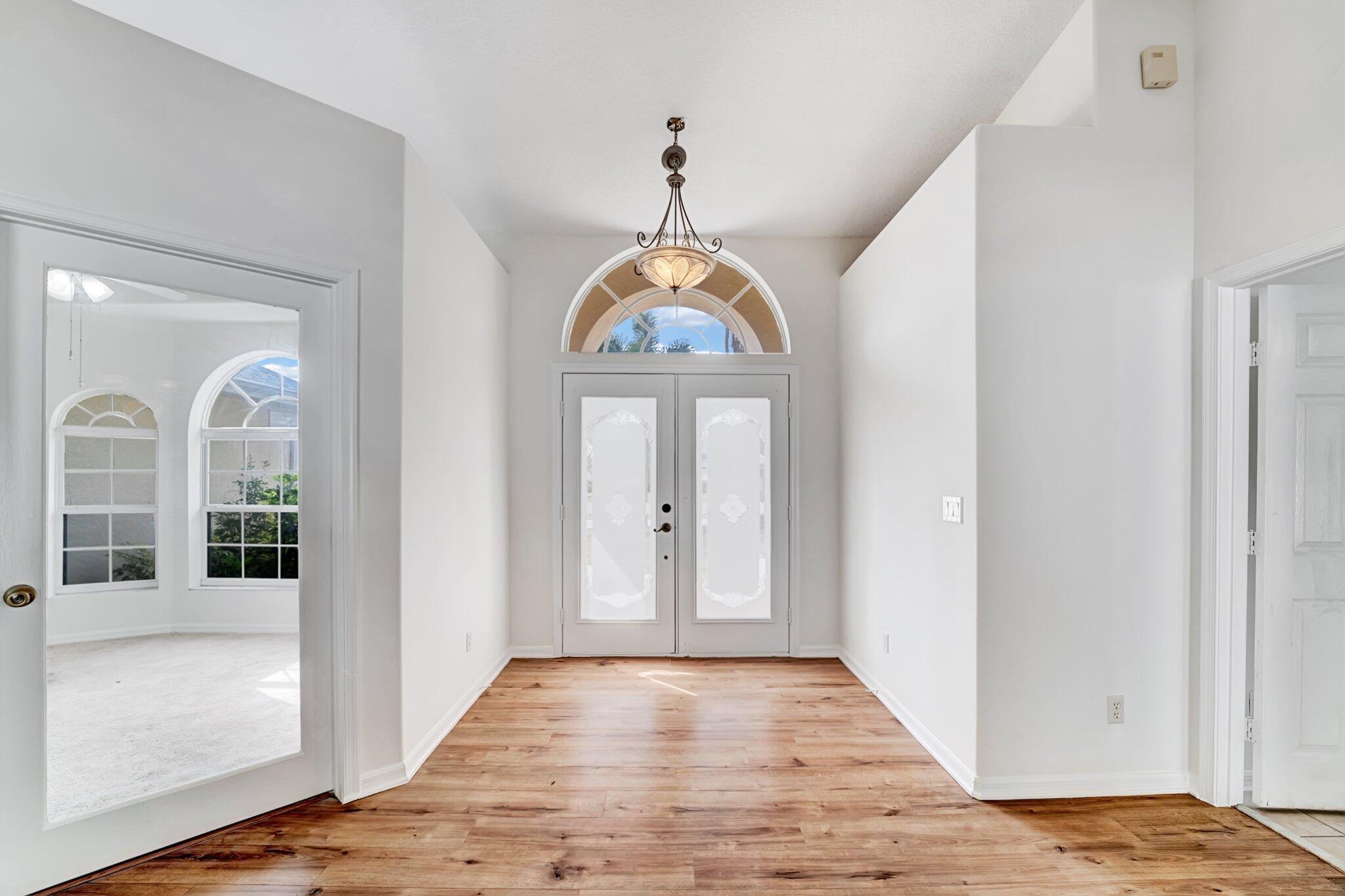 513 Southeast Cliff Road Port St. Lucie, FL 34984 - Photo 2 of 39 a view of an entryway with wooden floor