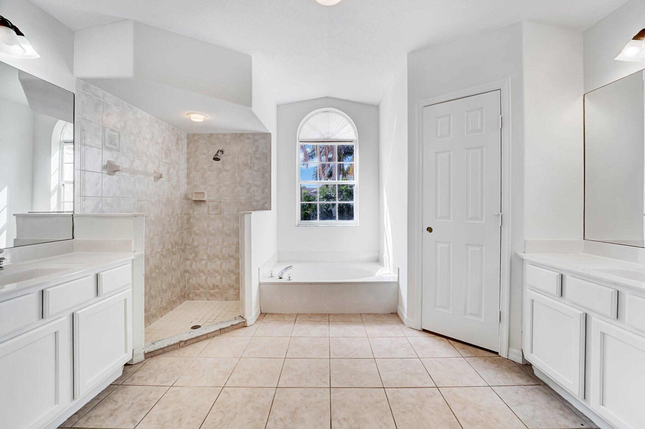 513 Southeast Cliff Road Port St. Lucie, FL 34984 - Photo 22 of 39 a bathroom with a bathtub and a shower