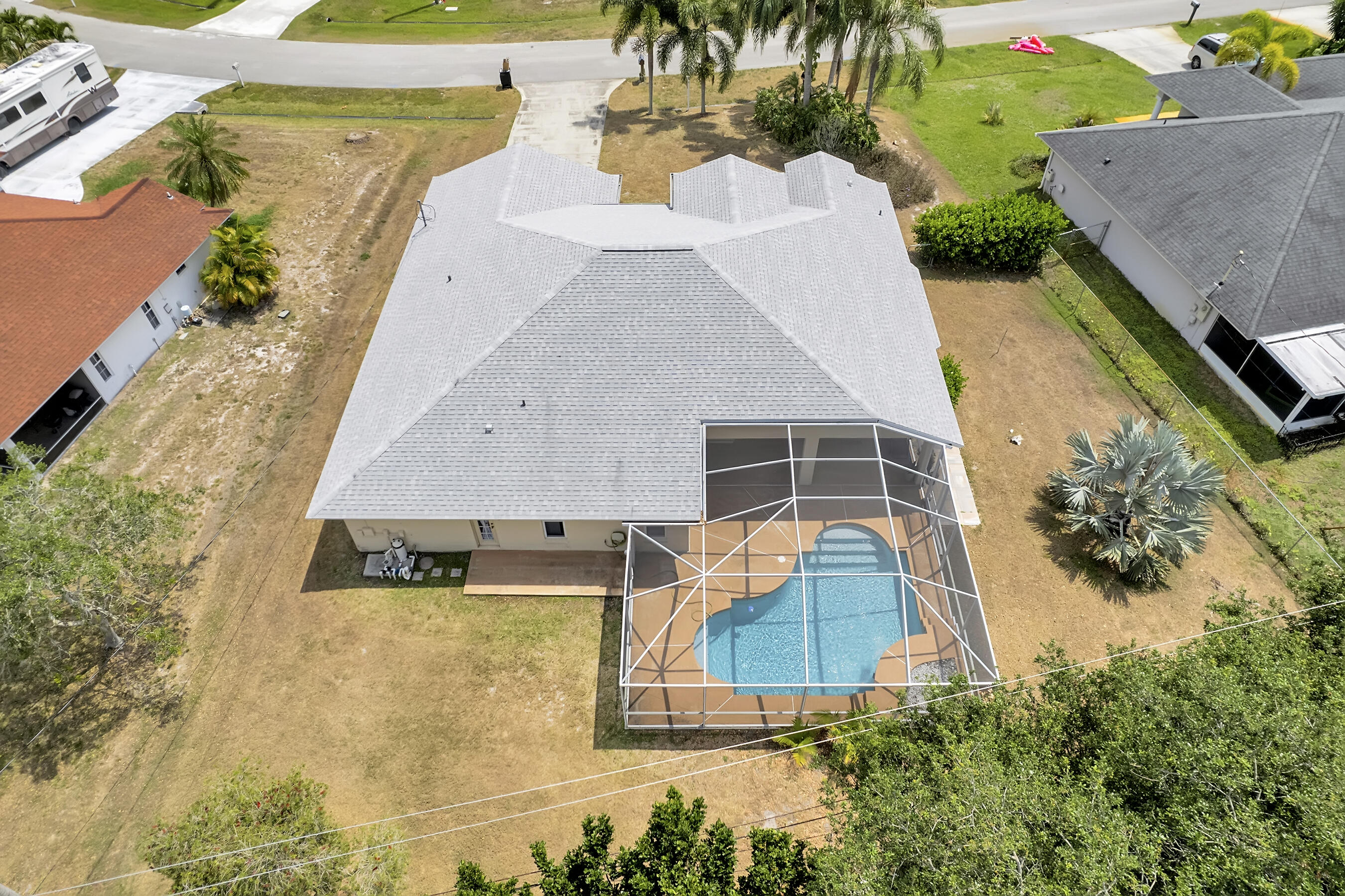 513 Southeast Cliff Road Port St. Lucie, FL 34984 - Photo 36 of 39 an aerial view of a house with swimming pool and large trees