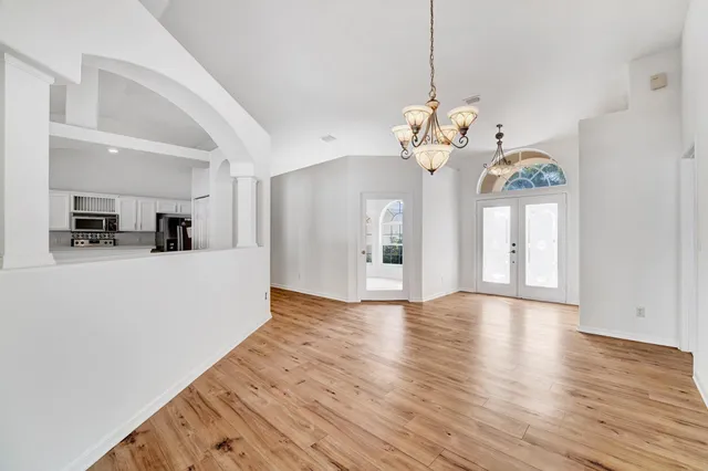 a view of a house with chandelier fan and wooden floor