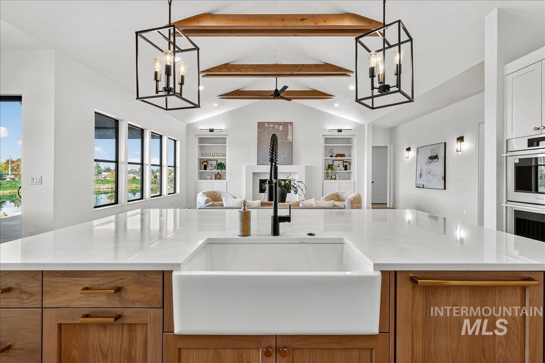 486 Joy Avenue Middleton, ID 83644 - Photo 8 of 36 Kitchen with a chandelier, decorative light fixtures, brown cabinets, a fireplace, and recessed lighting