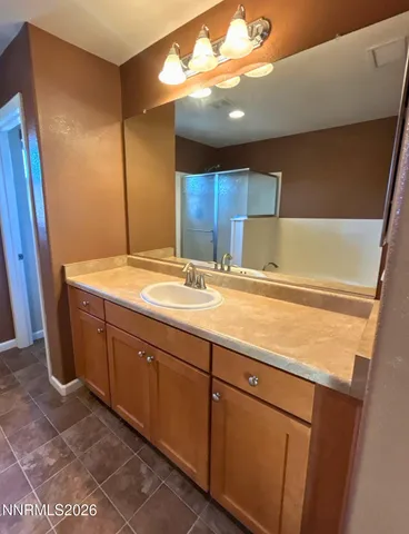 a room with a sink a vanity and a large mirror