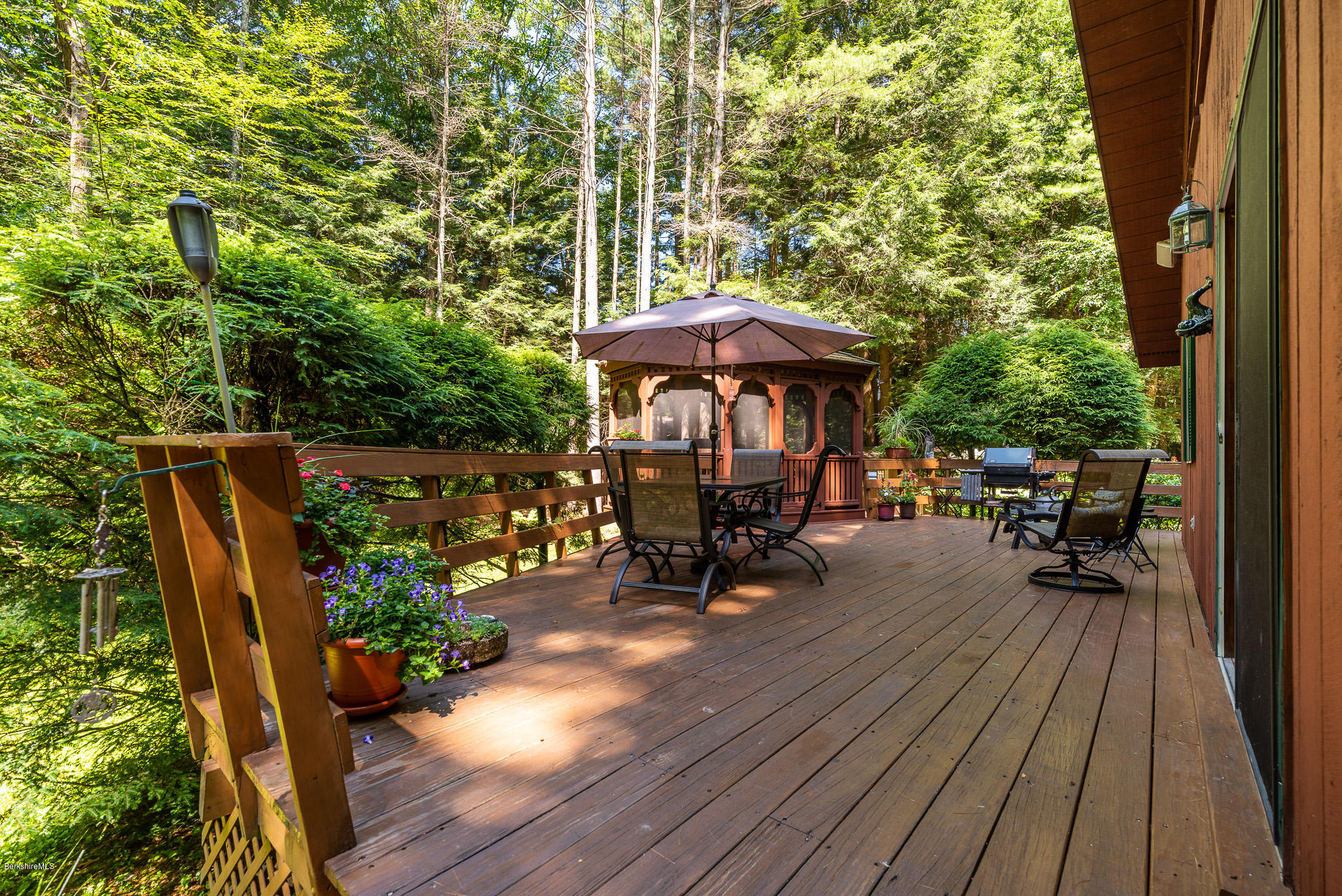 811 Salisbury Road Sheffield, MA 01257 - Photo 26 of 39 a view of a deck with table and chairs under an umbrella with wooden floor