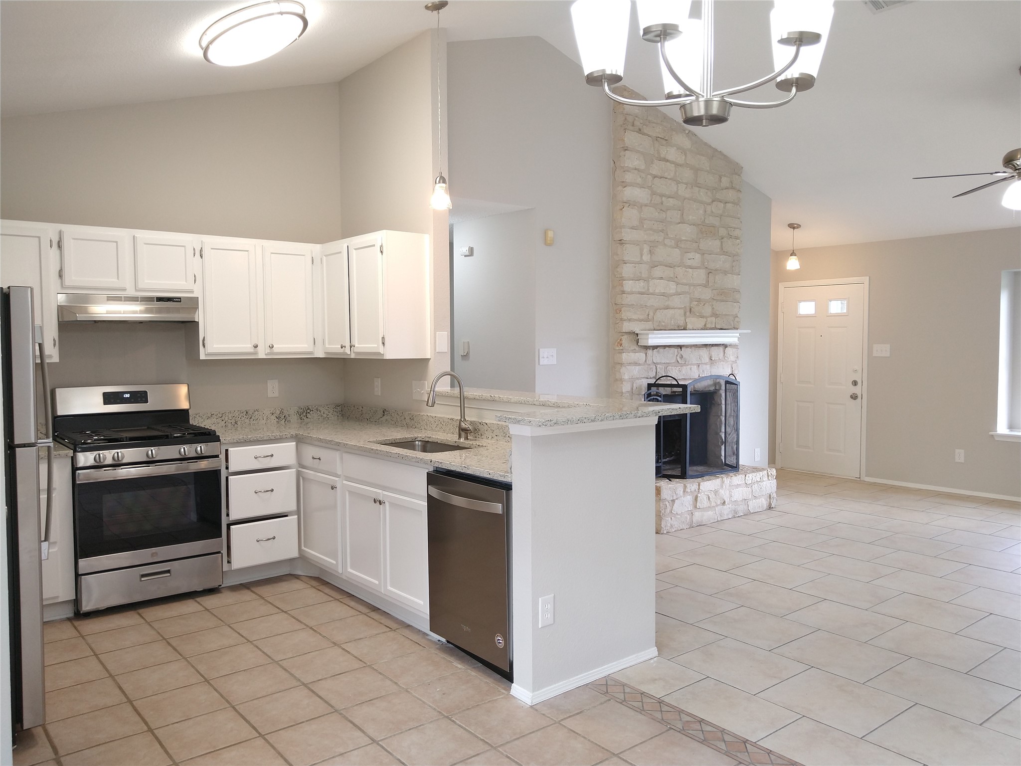 1813 Laurel Path Round Rock, TX 78664 - Photo 13 of 35 A contemporary open-concept layout features a well-appointed kitchen and a stone-clad fireplace.