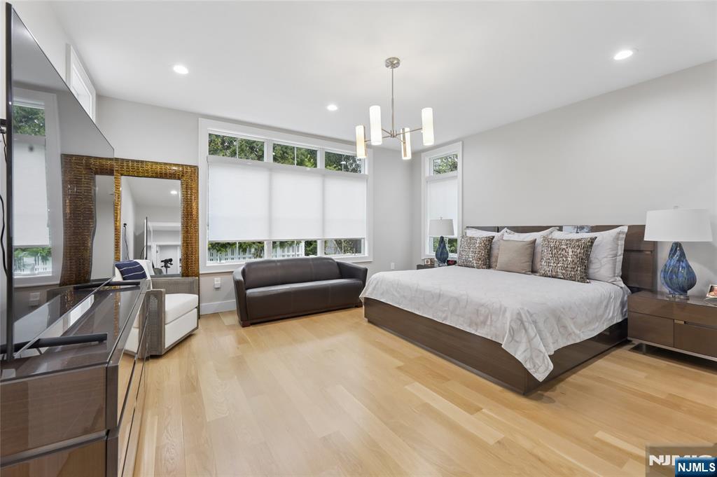31 Engleside Street Cresskill, NJ 07626 - Photo 17 of 49 a spacious bedroom with a bed a couch and large windows