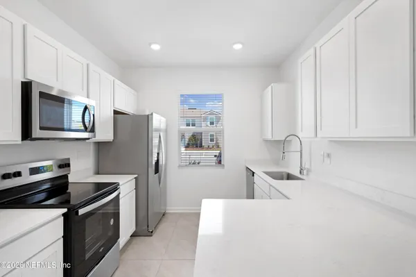 a kitchen with stainless steel appliances a stove microwave and sink