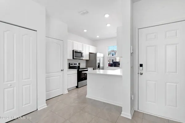 a kitchen with white cabinets and stainless steel appliances