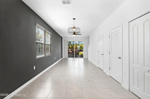 a hallway with windows and chandelier