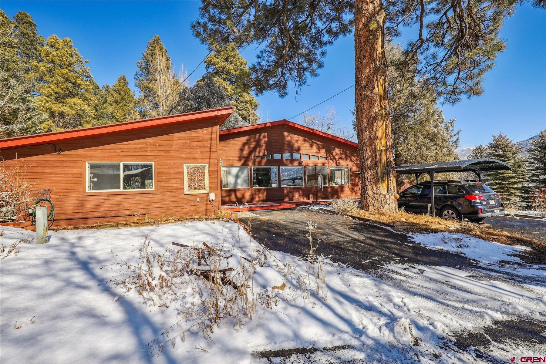 6815 County Road 203 Durango, CO 81301 - Photo 1 of 35 a front view of a house with a yard covered with snow in front of house