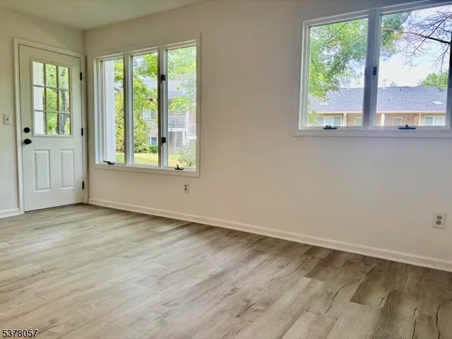 an empty room with wooden floor and a window