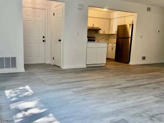 a view of a refrigerator in kitchen and wooden floor