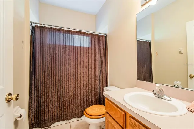 a bathroom with a sink a toilet and shower curtain