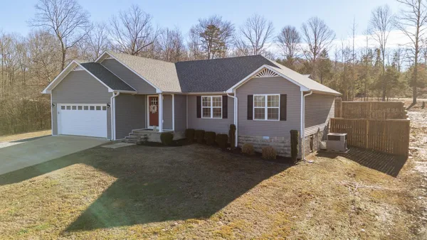 a view of a house with a yard covered in snow