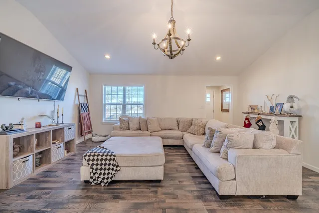 a living room with furniture chandelier and a flat screen tv