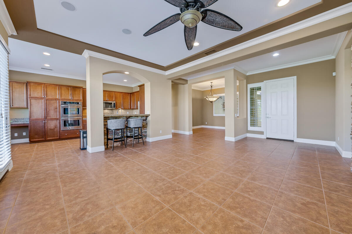 112 Rosetta Court Palm Desert, CA 92211 - Photo 3 of 41 a view of a livingroom with a flat screen tv wooden floor and a ceiling fan