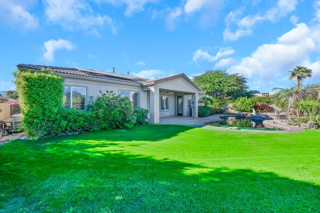 a swimming pool with outdoor seating and plants