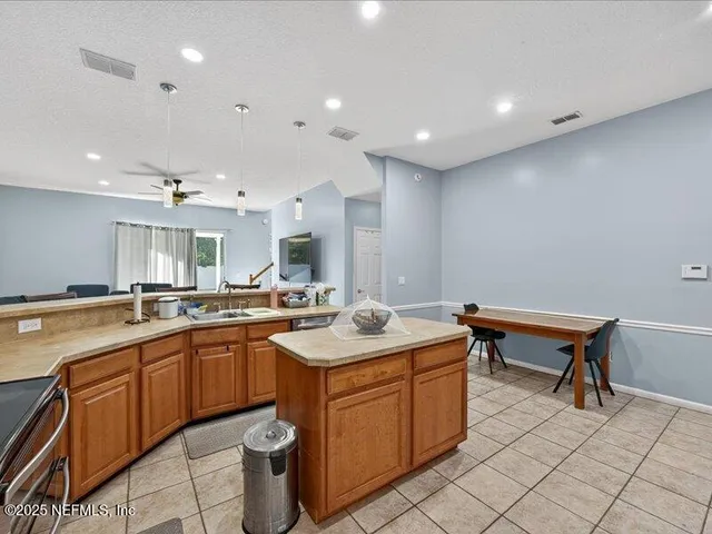 a kitchen with a sink a stove a dining table and chairs