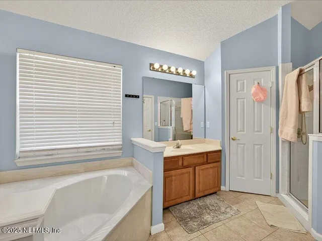 a bathroom with a tub sink and mirror