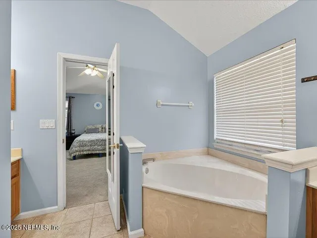 a en suite bathroom with a granite countertop sink and a mirror