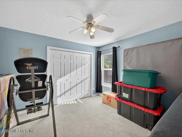 a bedroom with furniture and a chandelier fan