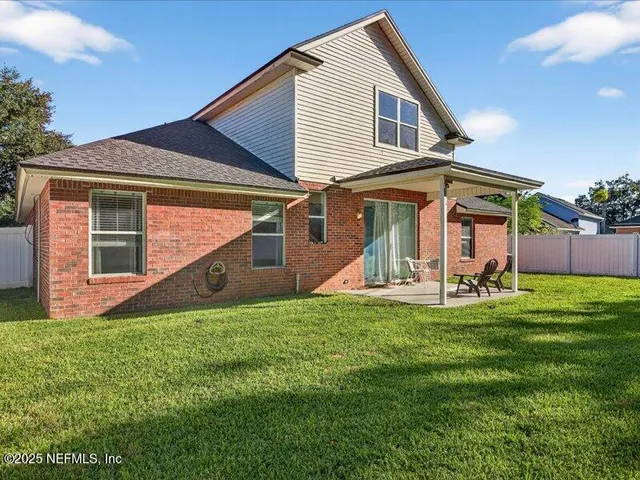 a view of a house with a yard and a patio
