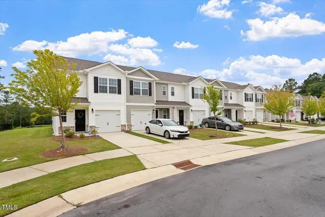 a view of a white house with a yard patio and fire pit