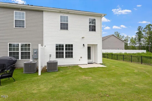 a backyard of a house with barbeque oven table and chairs