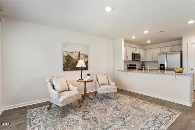a living room with furniture and kitchen view