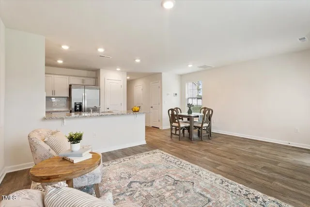 a living room with furniture and a dining table with kitchen view