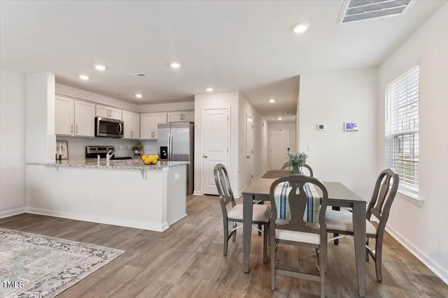 a view of kitchen with refrigerator dining table and chairs