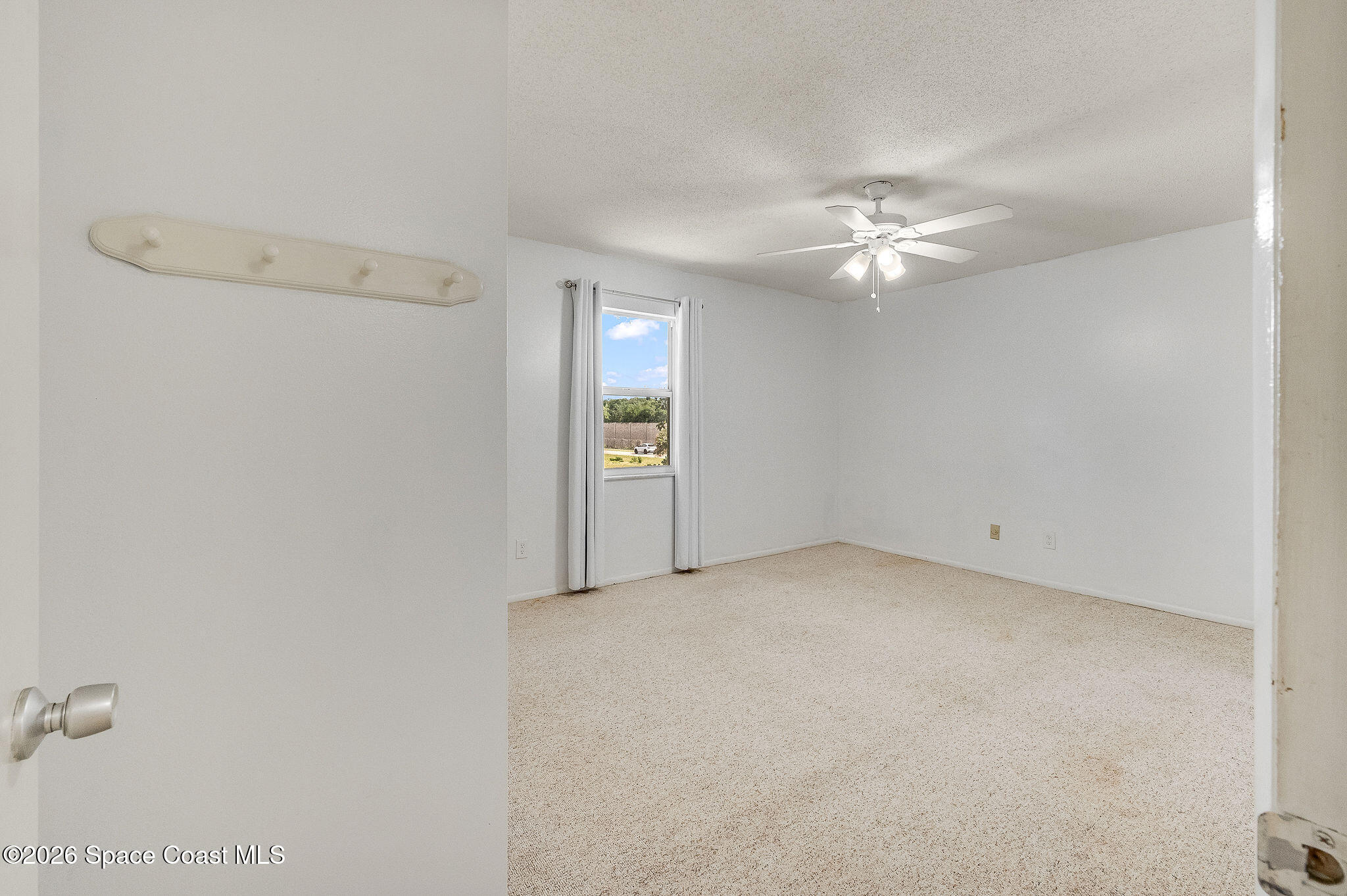 4304 London Town Road, Unit D224 Titusville, FL 32796 - Photo 11 of 32 an empty room with a ceiling fan and a window