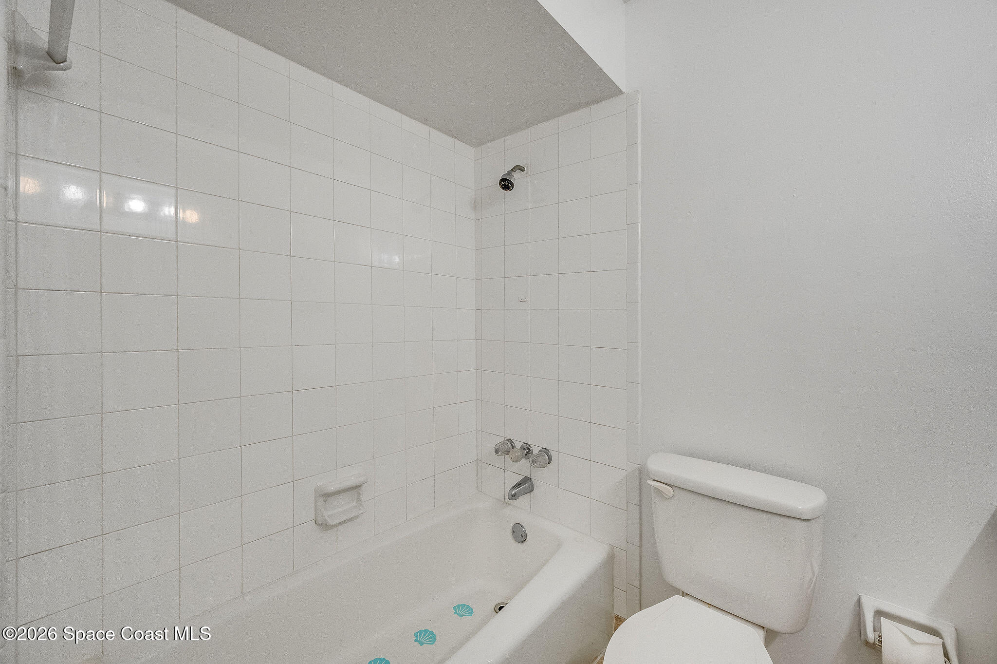 4304 London Town Road, Unit D224 Titusville, FL 32796 - Photo 19 of 32 a white toilet and tub sitting next to a bathroom sink