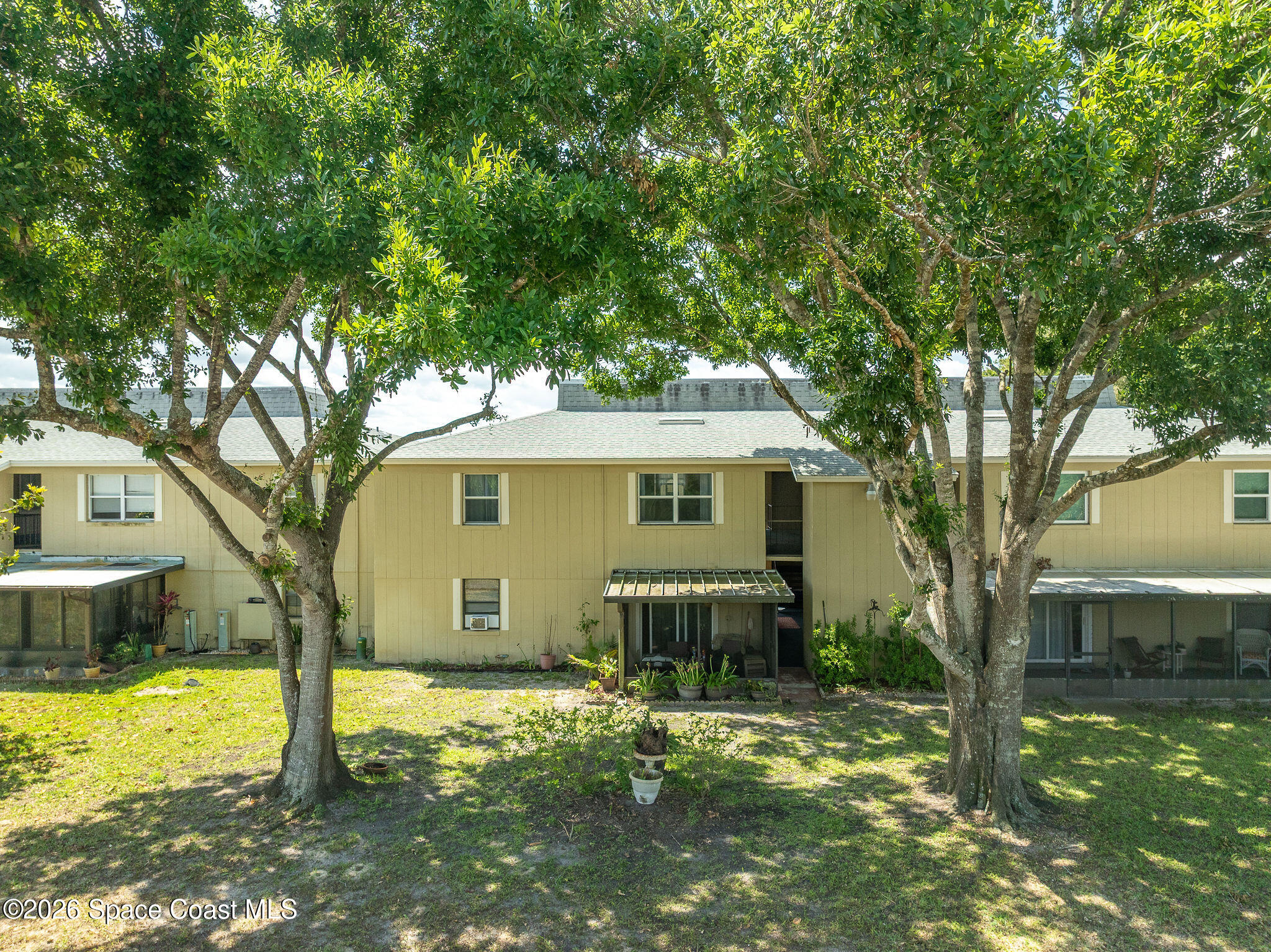4304 London Town Road, Unit D224 Titusville, FL 32796 - Photo 22 of 32 a front view of a house with a yard and large trees
