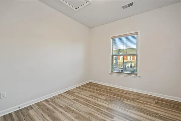 a view of an empty room with wooden floor