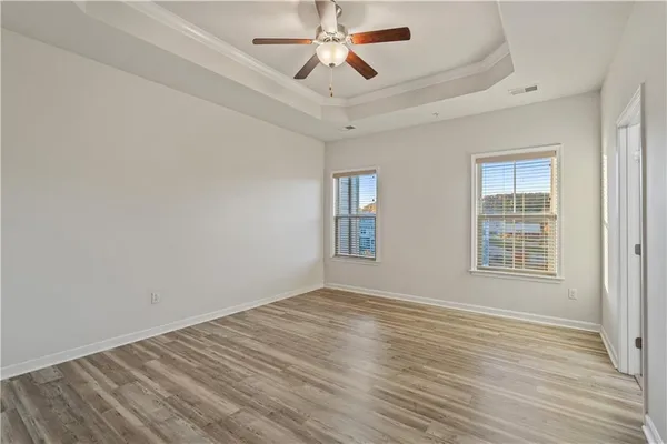 a view of kitchen and empty room with wooden floor