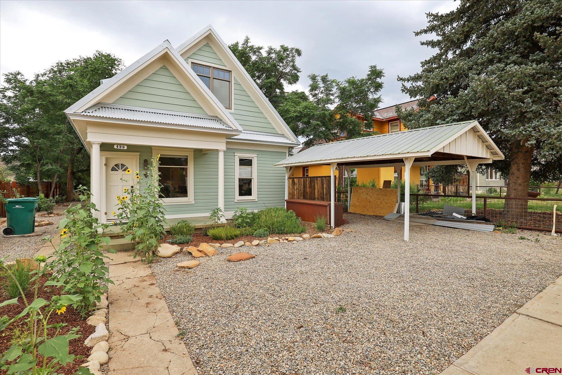 a view of a house with a yard and potted plants