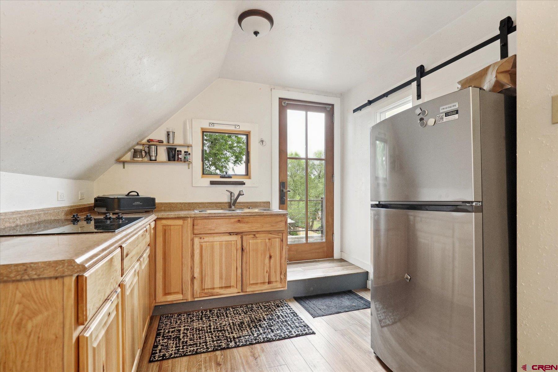 438 Bauer Avenue Mancos, CO 81328 - Photo 26 of 30 a kitchen with a refrigerator a sink and cabinets