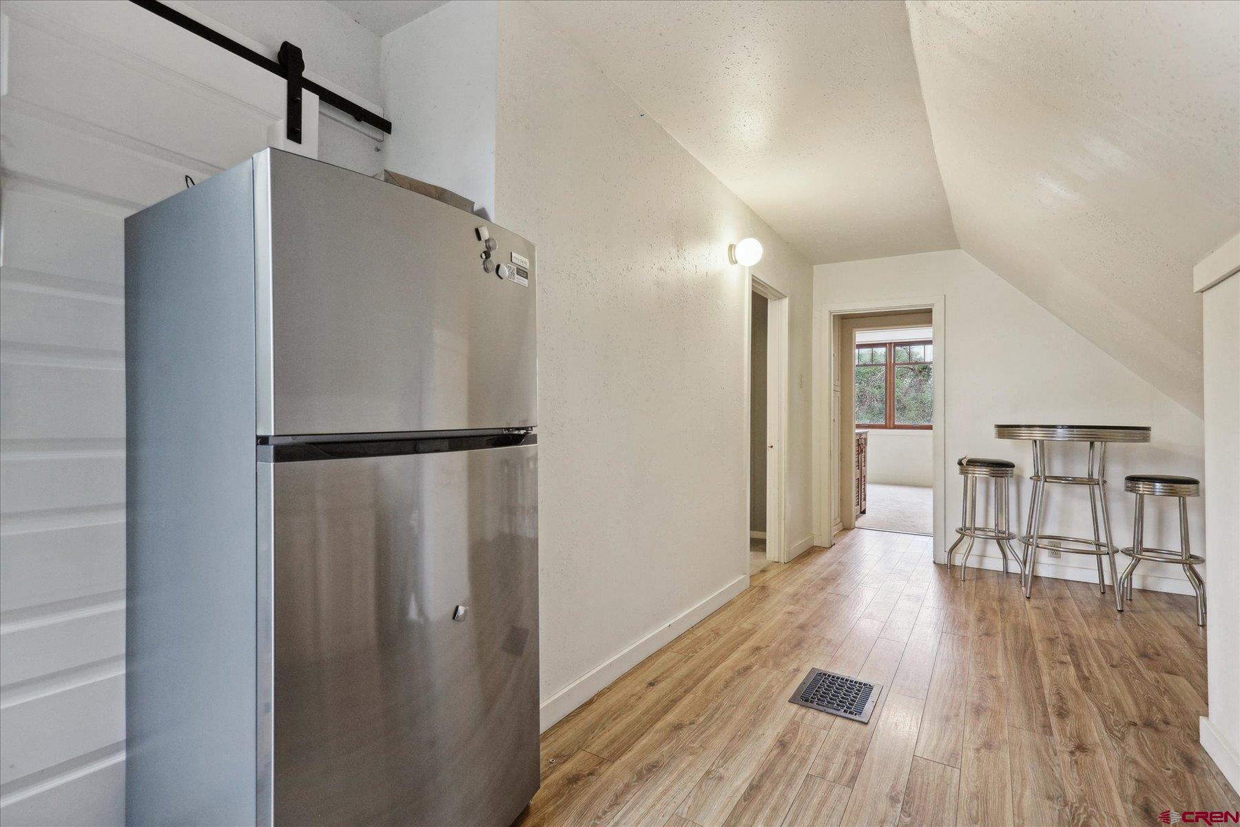 438 Bauer Avenue Mancos, CO 81328 - Photo 27 of 30 a view of a kitchen with wooden floor and a refrigerator
