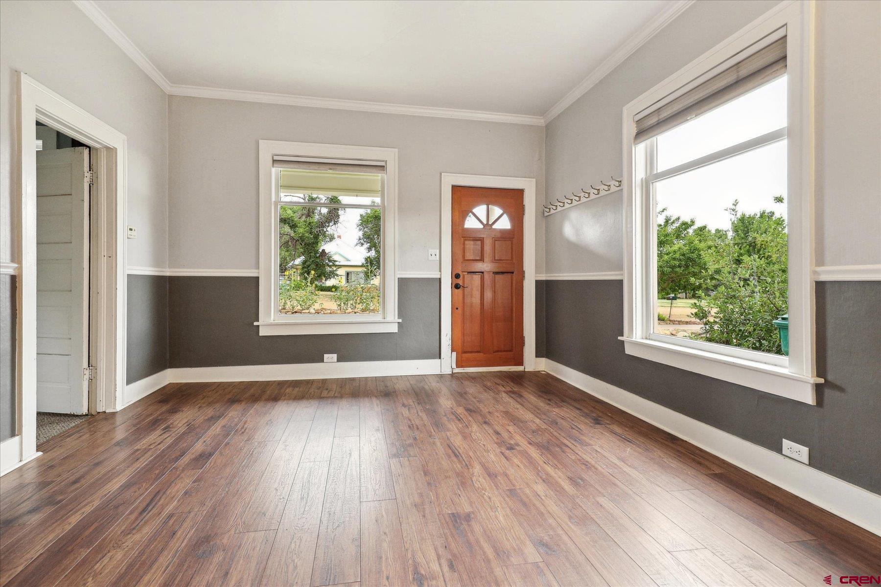 438 Bauer Avenue Mancos, CO 81328 - Photo 3 of 30 a view of an empty room with wooden floor and a window